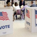 Voters receive their ballot to vote in the Super Tuesday election at Sleepy Hollow Elementary School in Falls Church, Virginia